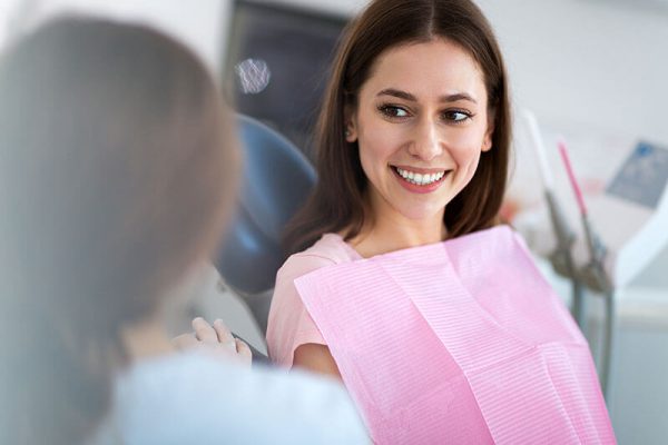woman siting in a dental chair and smiling