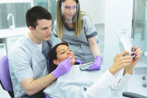 woman looking at her new smile at the dentist