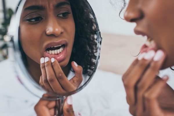 woman looking at her teeth in the mirror