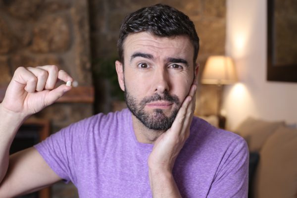 man holding his lost tooth